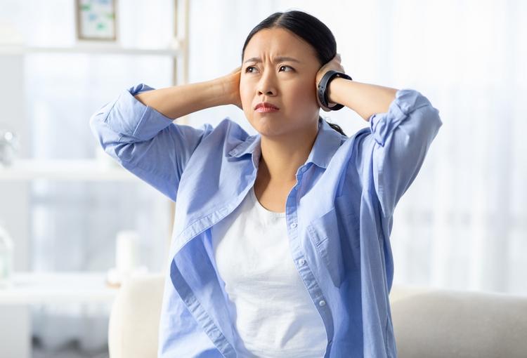 耳をふさぐ女性