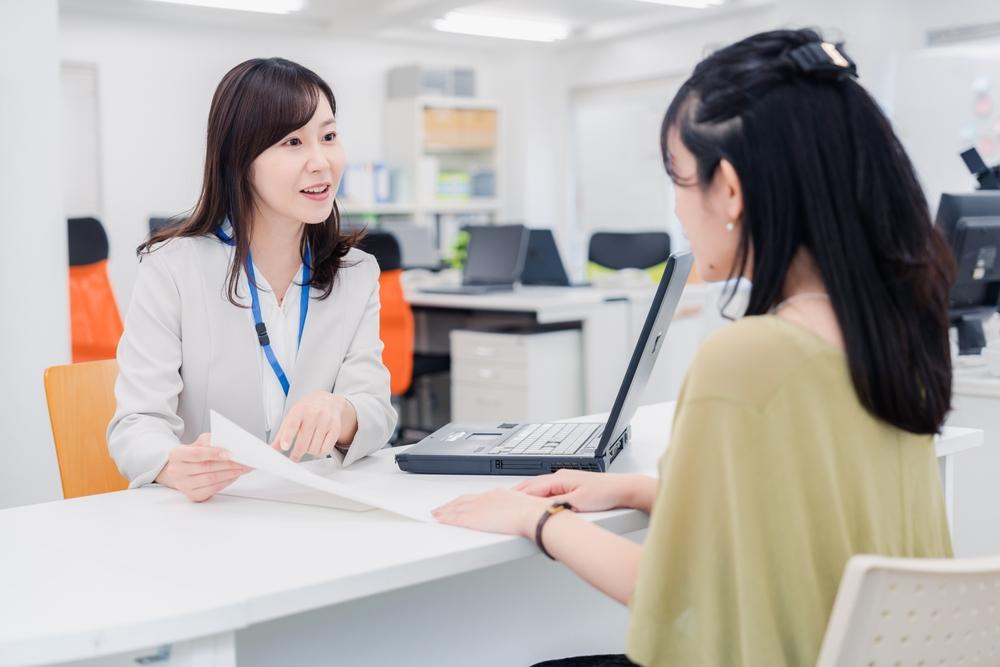 店舗で契約について説明を受けている女性