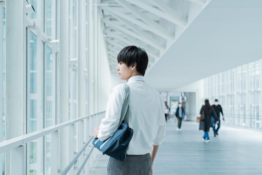 キャンパス内を歩く男子学生