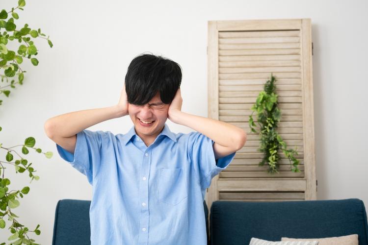 騒音に悩まされている男性の画像