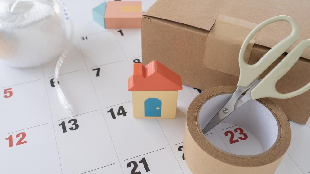 引越しを想起するカレンダーと荷造り用具