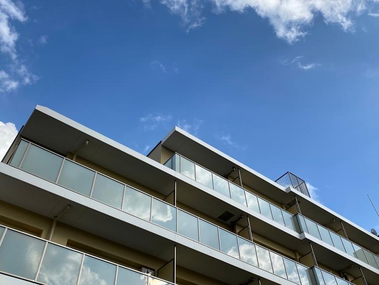 マンションを見上げた背景に青空